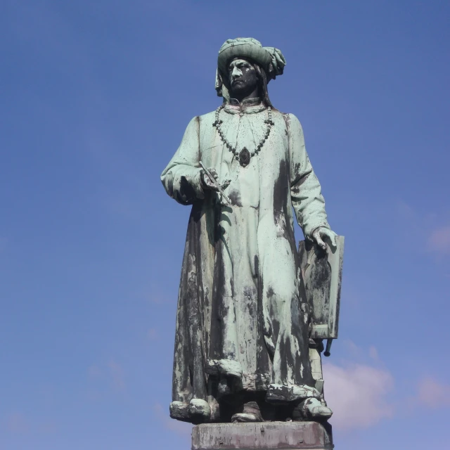 a statue is pictured against the sky with clouds