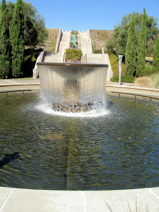 a large water fountain has a row of steps on each side