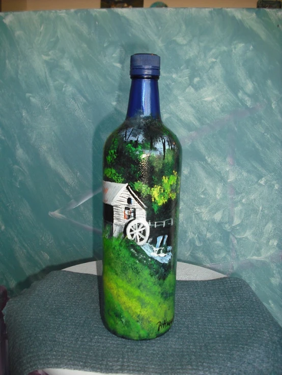 a blue glass bottle sits on a table with a painting