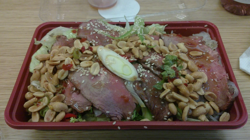 red plate of food sitting on a wooden table