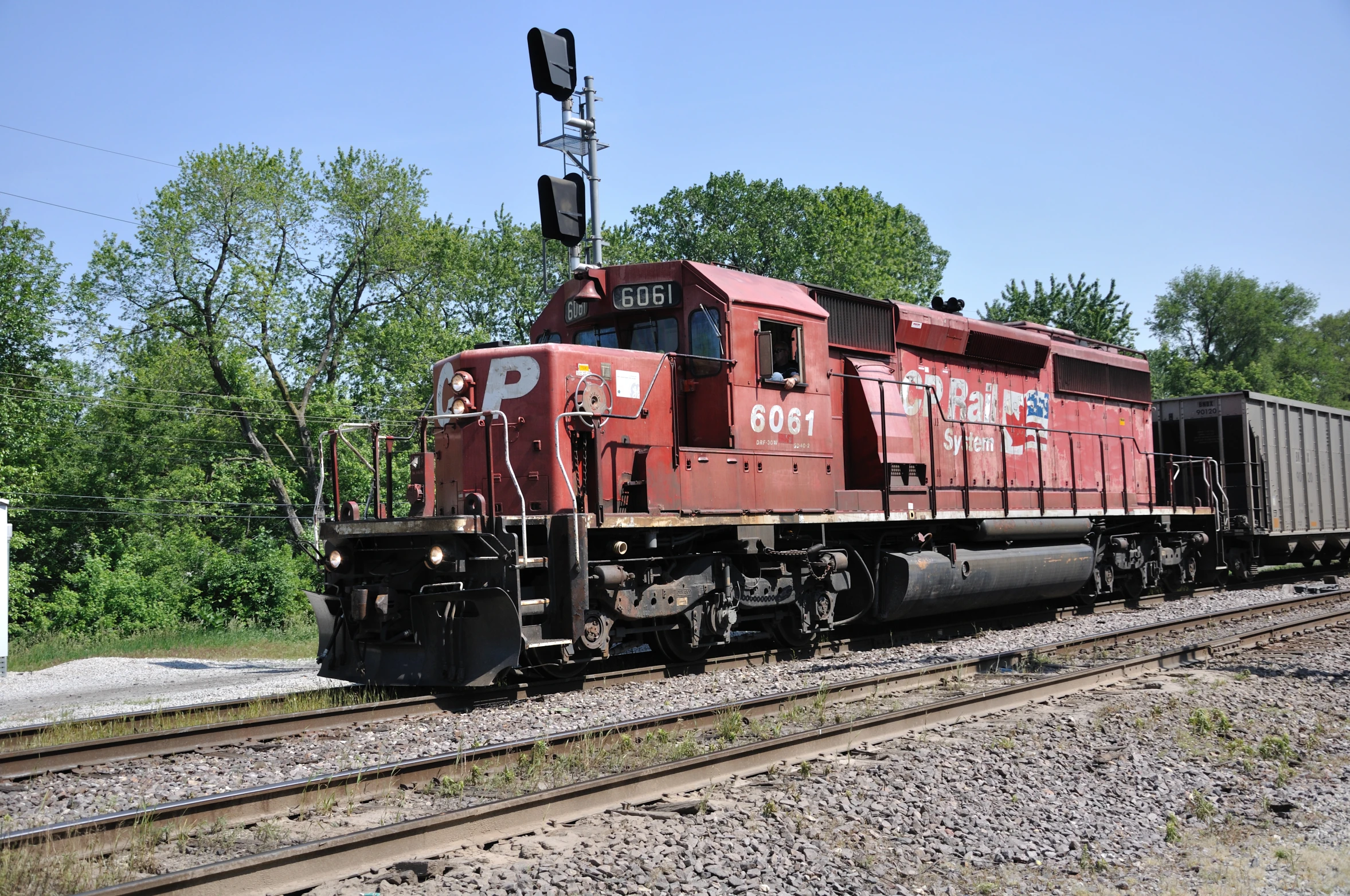 a red train traveling down tracks next to trees