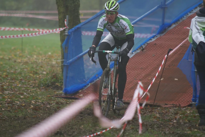 a man riding a bicycle on a course with a crowd watching