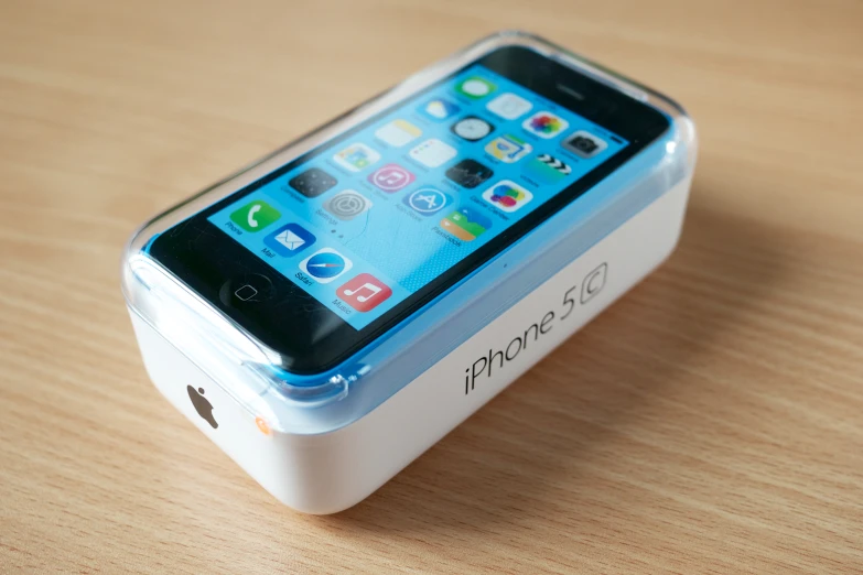 an iphone charging on top of a box on a table