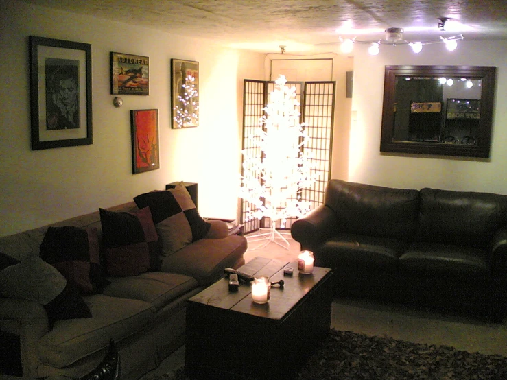 a living room with couches and candles on the table