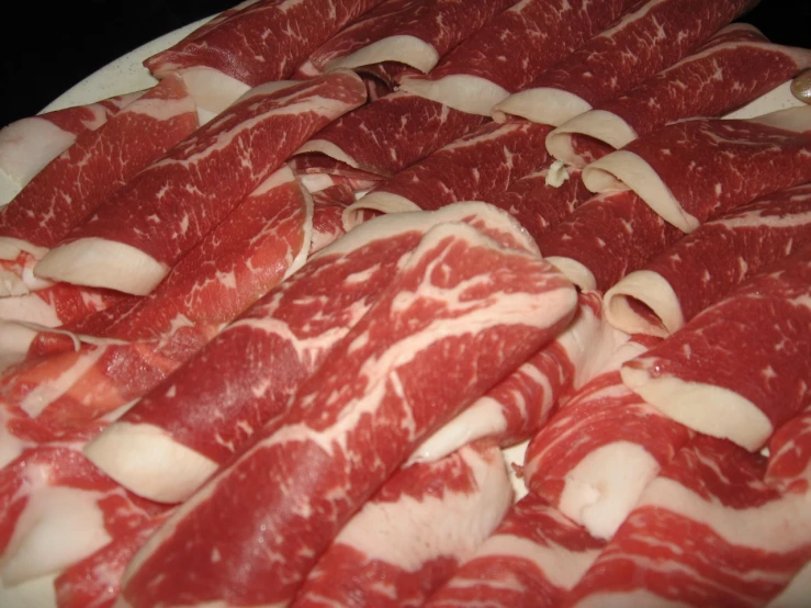 meat cuts up on a white plate with other meats