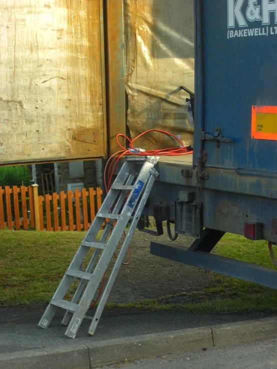 there is a ladder attached to the front of a blue garbage truck