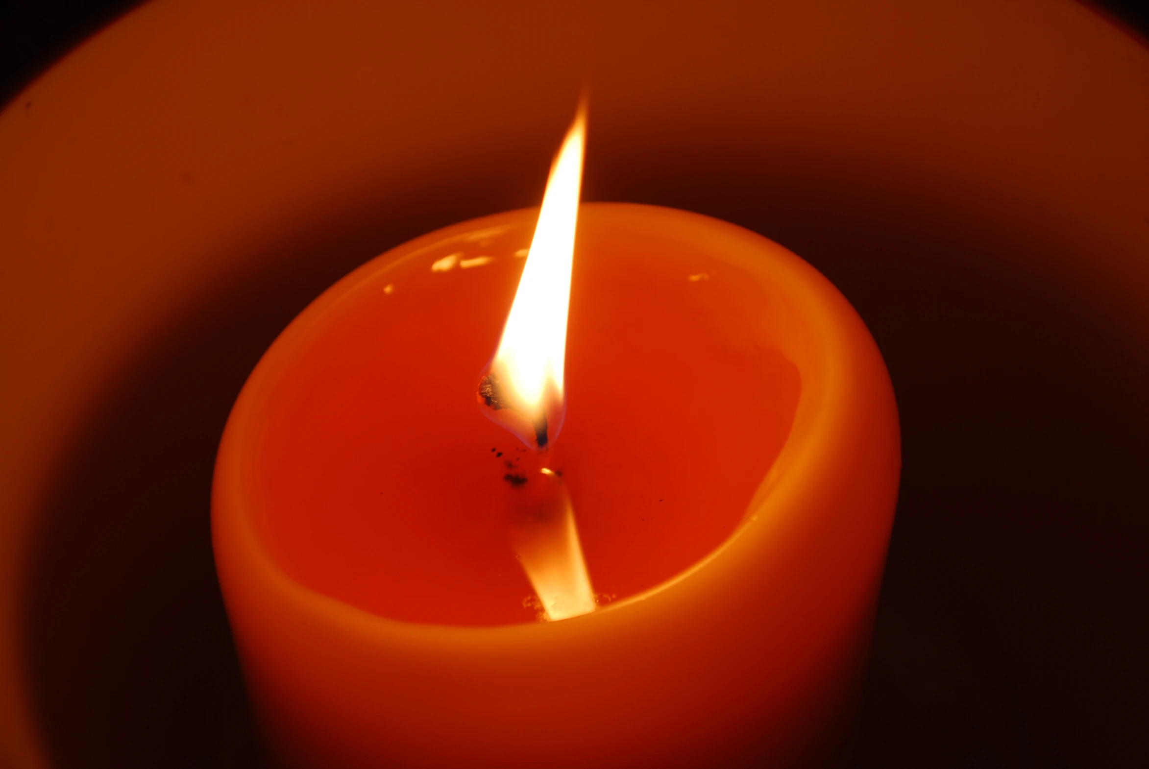 an orange candle with a single burning candle sticker in it
