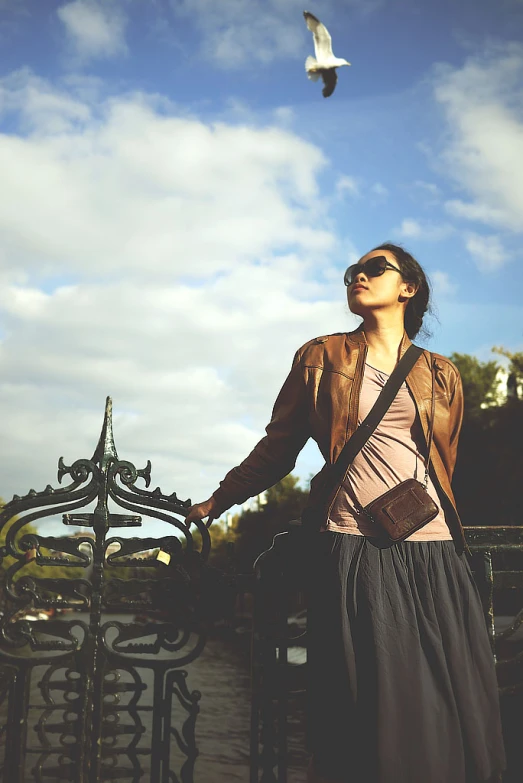 woman looking up at sky, with bird flying overhead