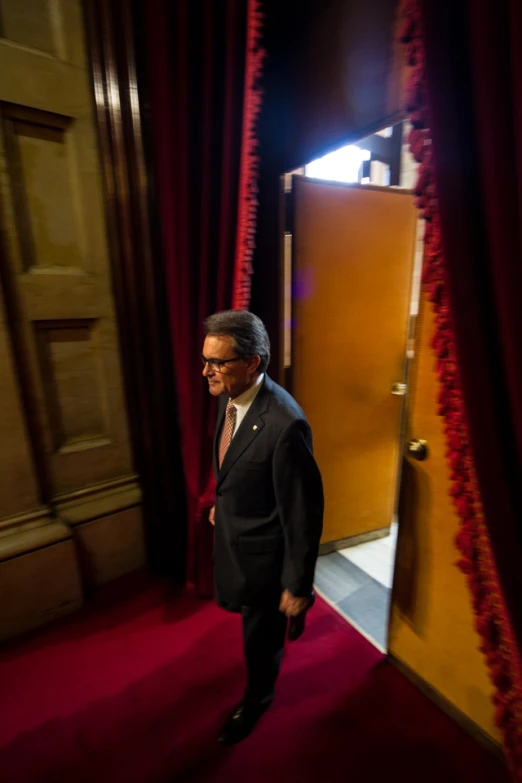 a man in suit and tie standing in front of a doorway