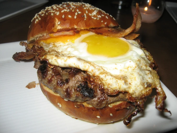 the hamburger on the plate is made with cheese, meat and an egg