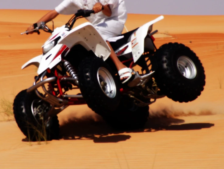 a man riding a quad in the desert