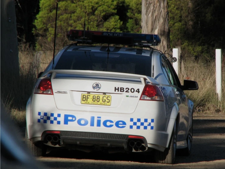 police car with its lights on driving down a street