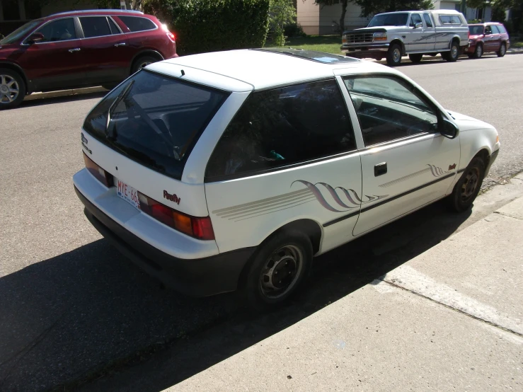 a small white car parked on the side of a street