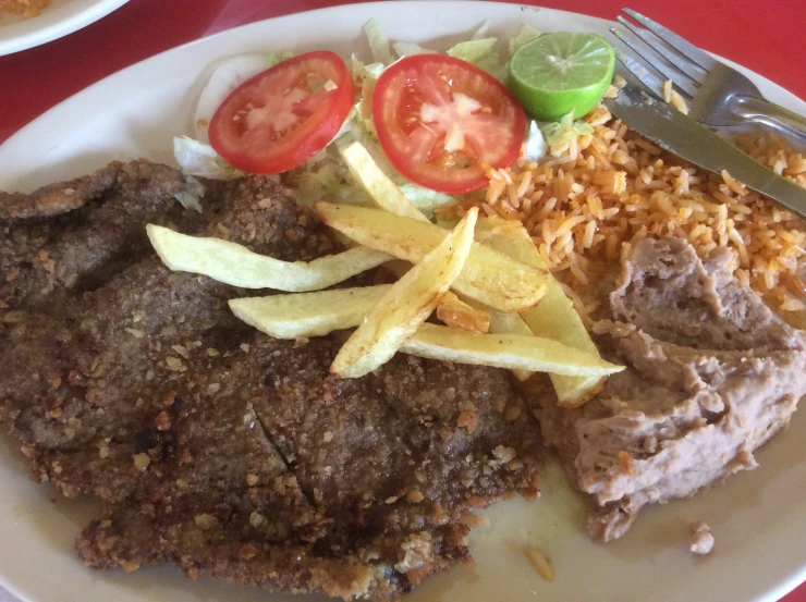 a plate of food with meat, beans and vegetables