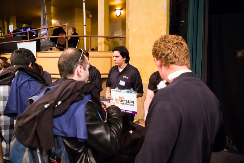 men gathered around in a hall holding signs