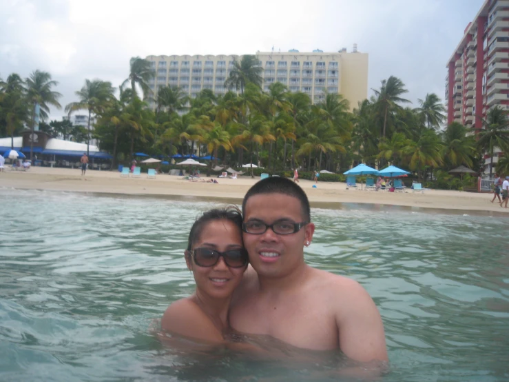 two people posing in water at a resort