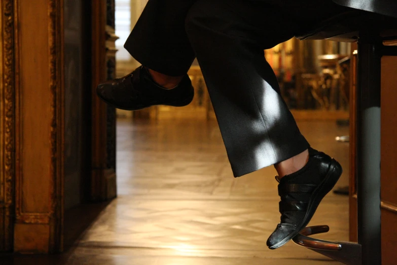 a close - up of the foot of a man in a suit, riding a skateboard