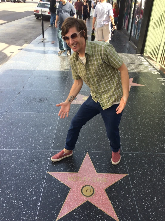 a man pointing his finger toward a star on the hollywood walk of fame
