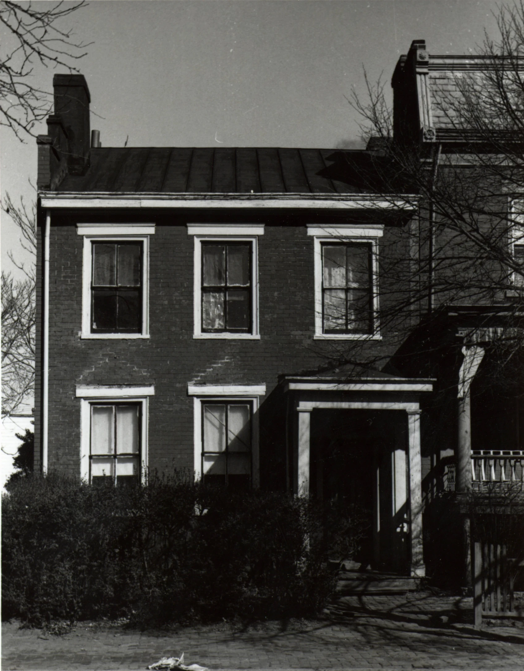 an old style house with large windows sitting next to a tree