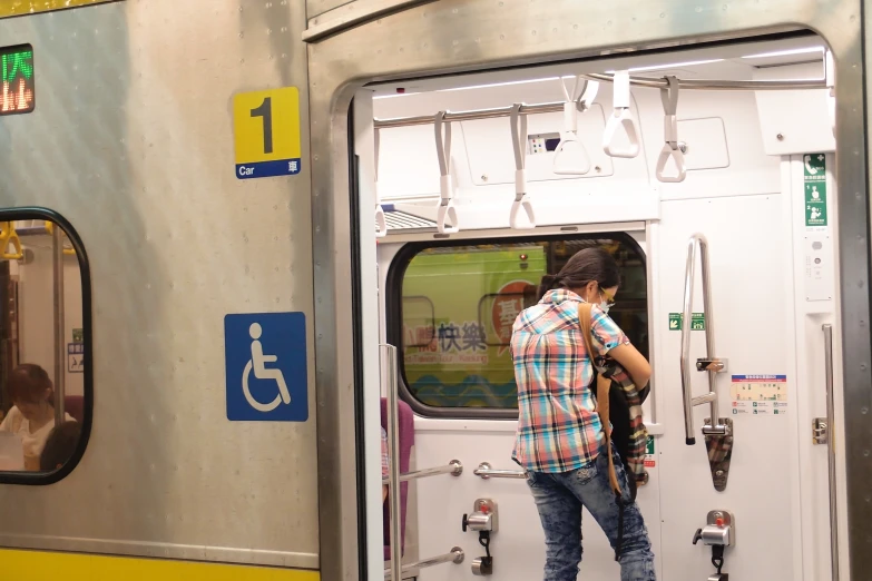 a woman stands on a train with a camera around her neck