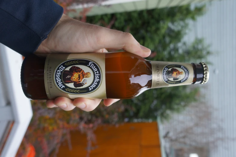 a person holding up a bottle of beer