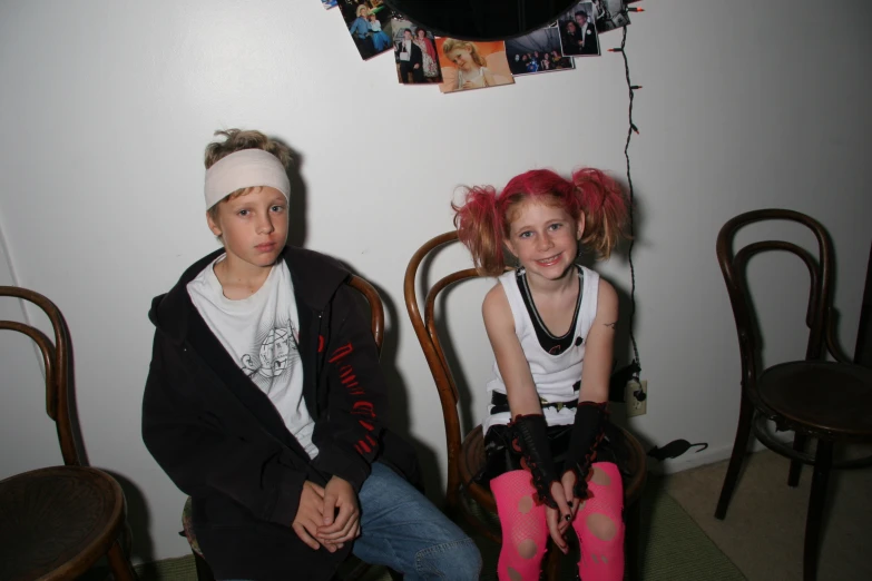 two s dressed in punk attire sit together