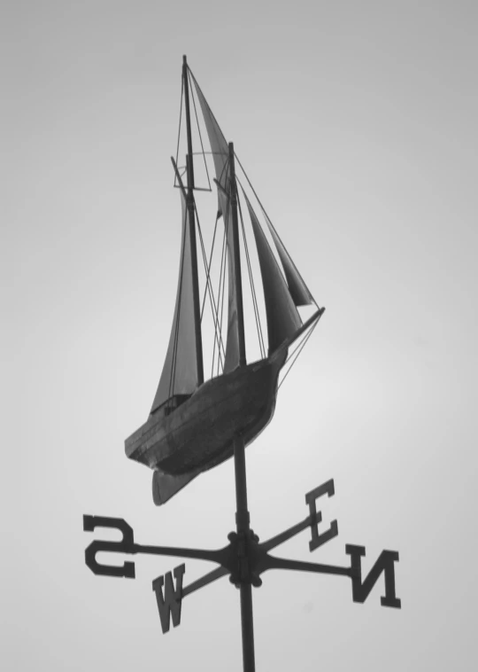 a weather vane with a sail on it