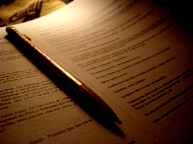 a pen sitting on an open book next to a pen