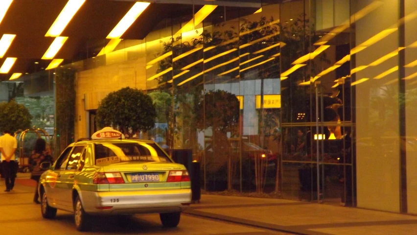 a taxi cab driving past an apartment building