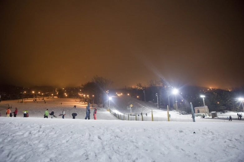 people on the snow at night in a large ski slope