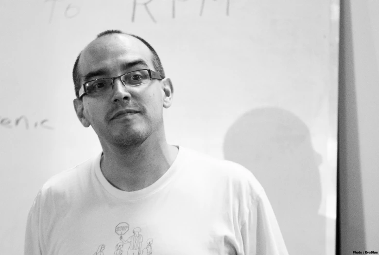 a man stands in front of a white board with writing on it