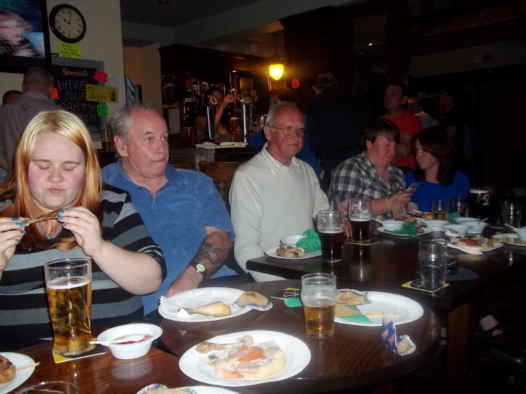 a group of people eating dinner at a bar