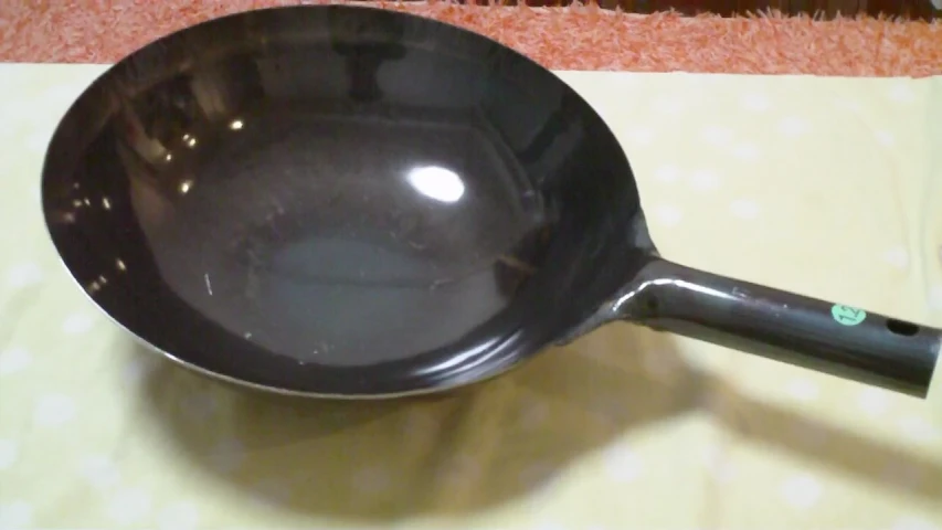 the large frying pan is attached to a plastic handle