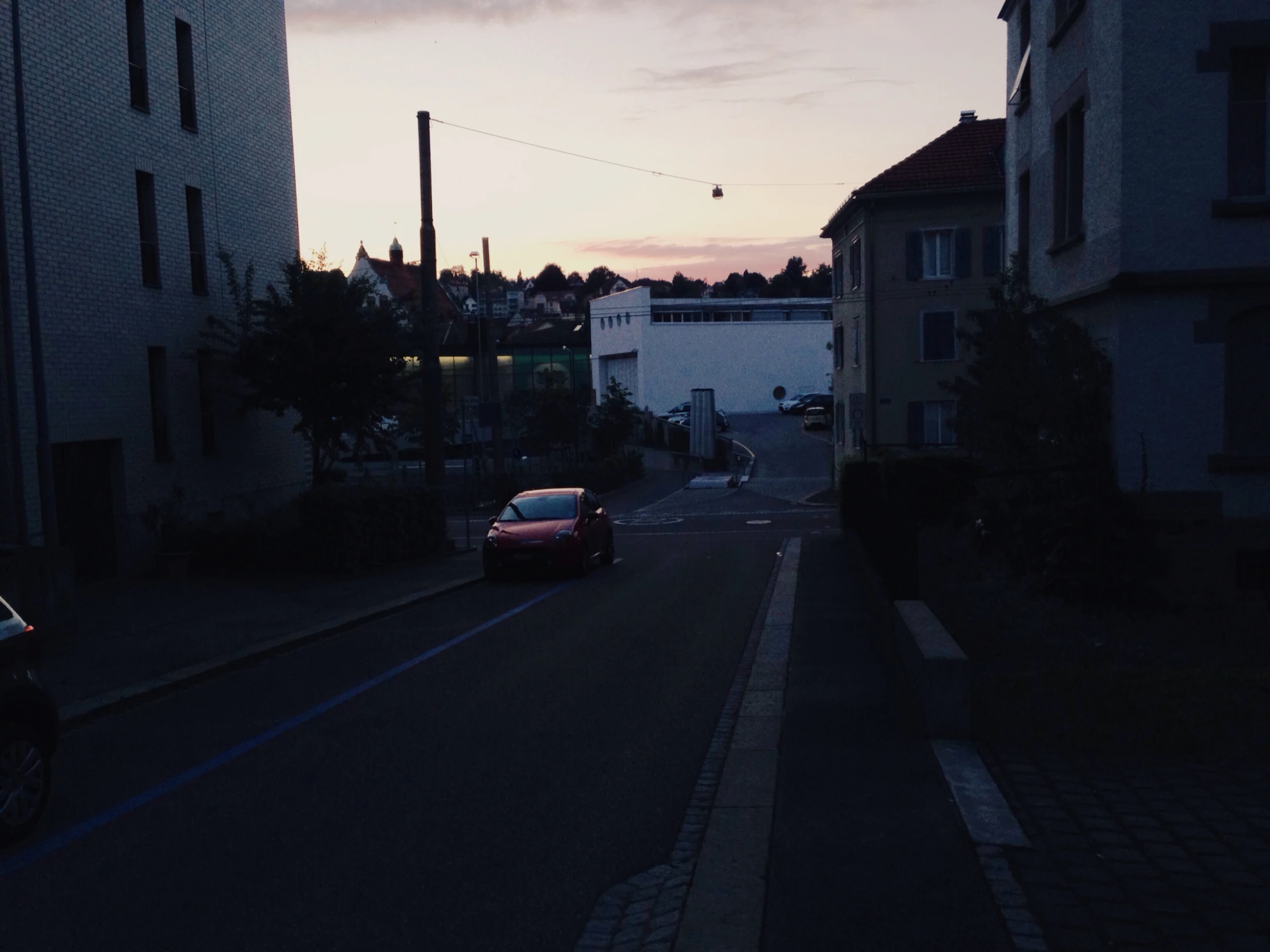 cars parked on a street next to apartment buildings