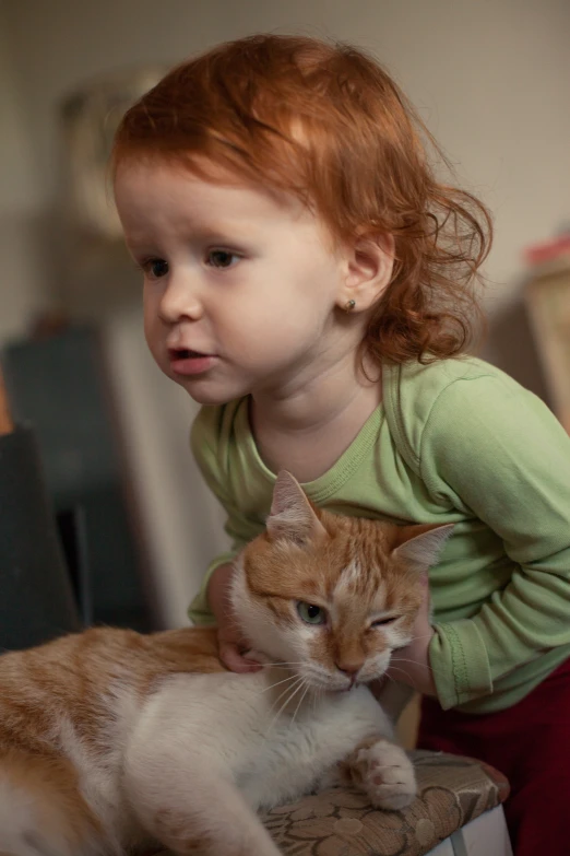 there is a girl holding a cat that is on the bench