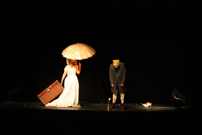 a woman and man holding an umbrella during a performance