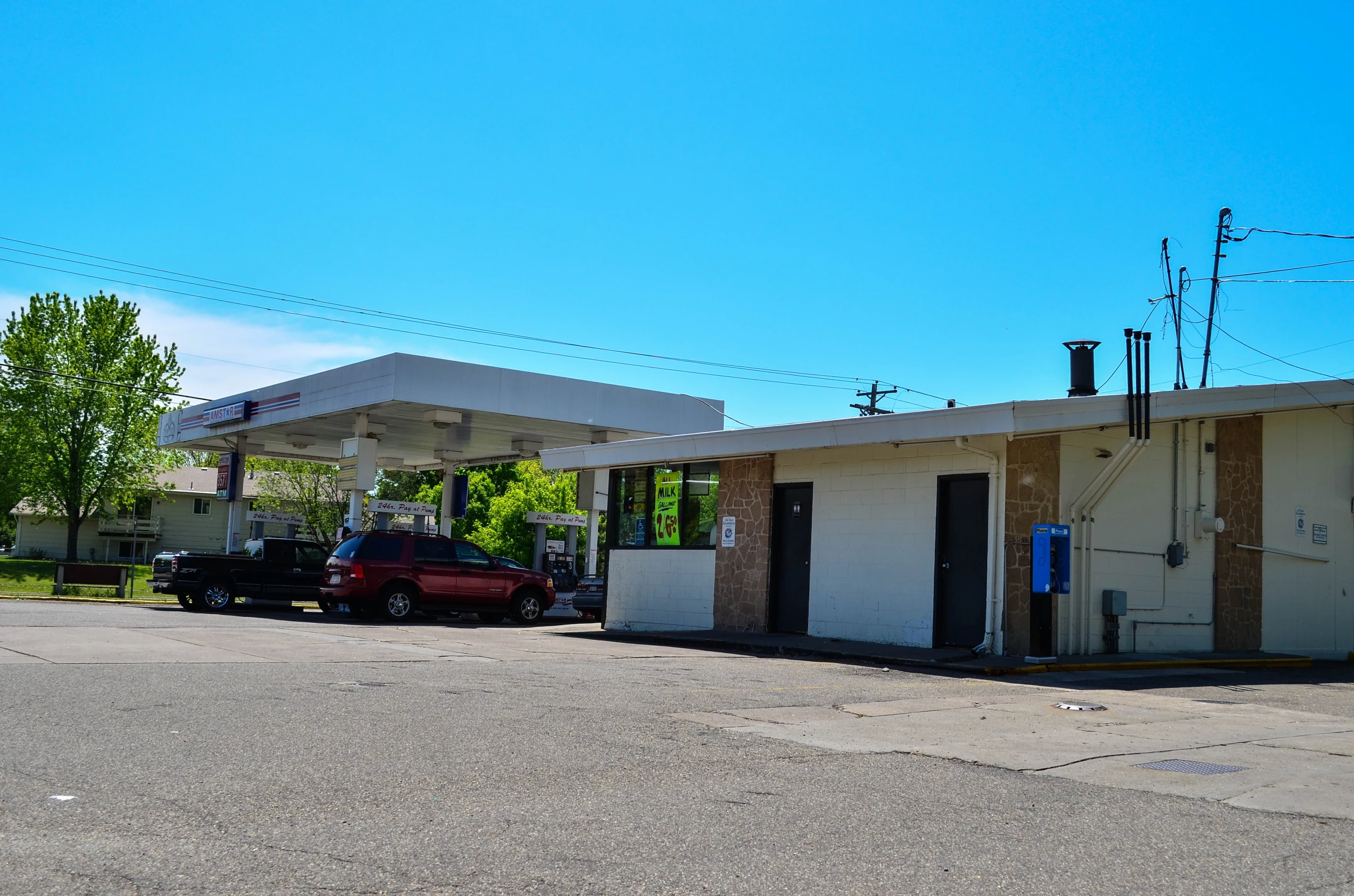 a gas station with two cars parked in the lot