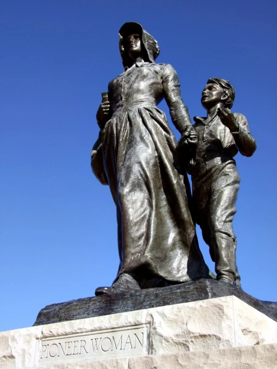 the statue shows a woman holding a boy's hand while standing by her back with a man on his shoulder