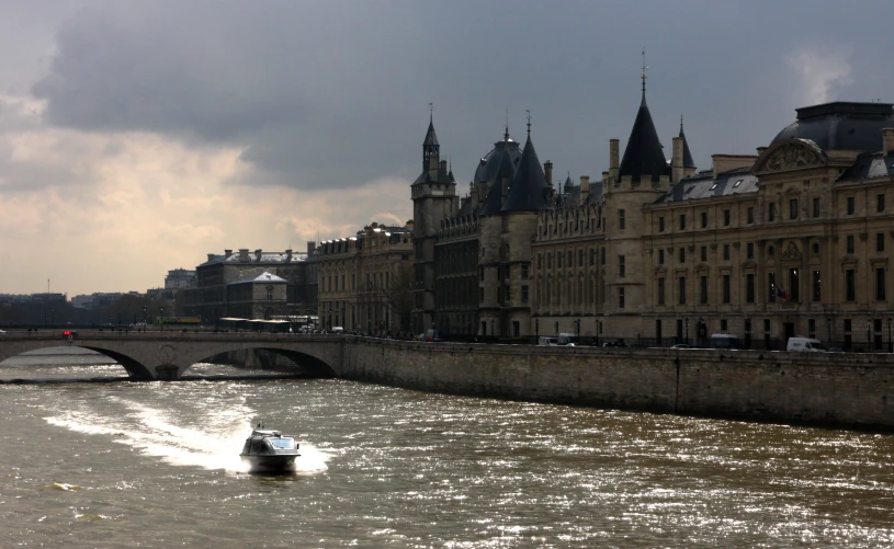 a boat sails down the river near a bridge