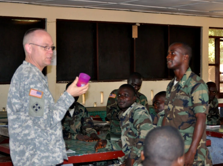 a woman in a military uniform showing another man soing purple