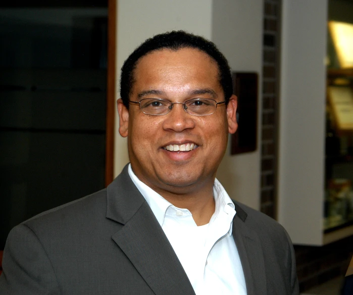 an image of a smiling man wearing glasses