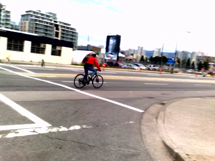 a person in red jacket on bicycle in the road