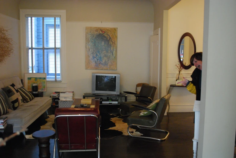 a living room with chairs and a television