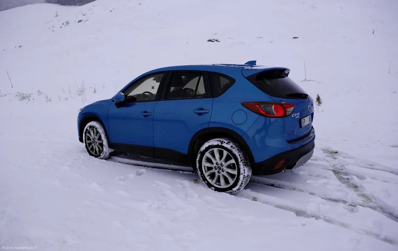 the blue car is on a snowy mountain