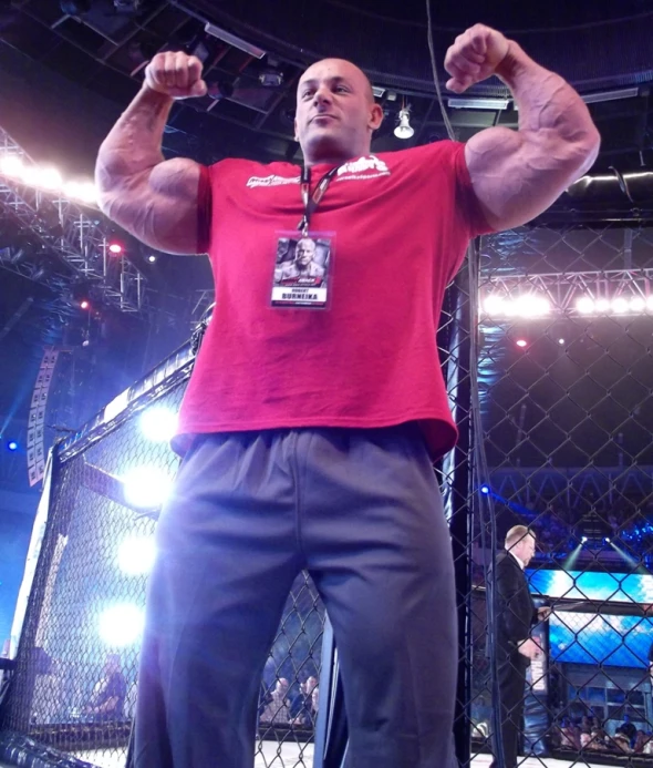 a man in a wrestling ring celetes with one arm raised