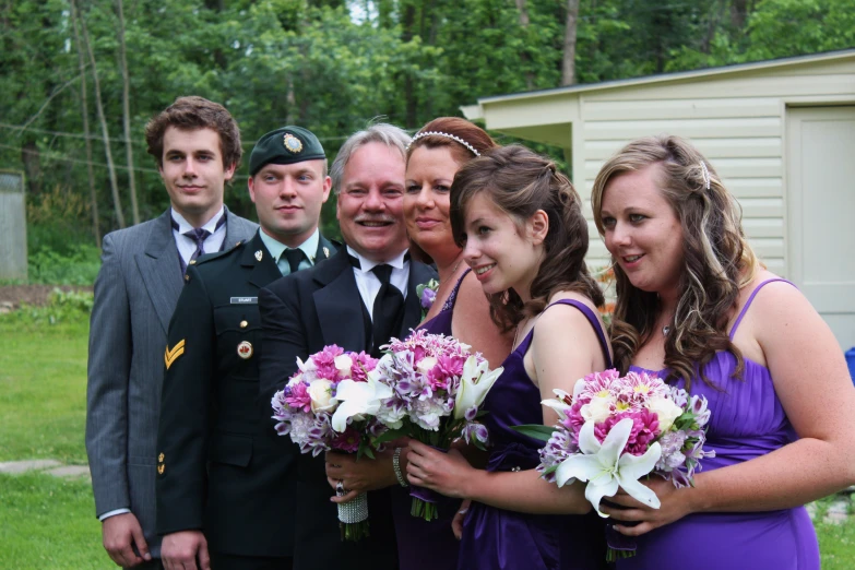 a group of people dressed in formal wear pose for the camera