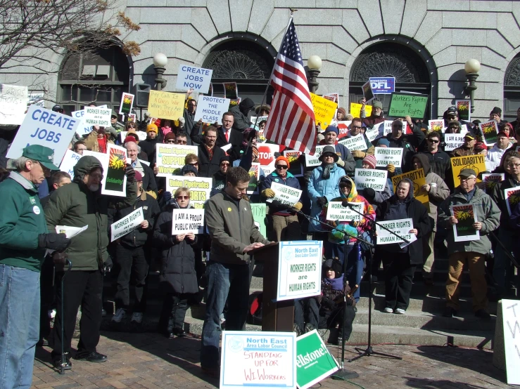 a crowd of people on the street holding signs