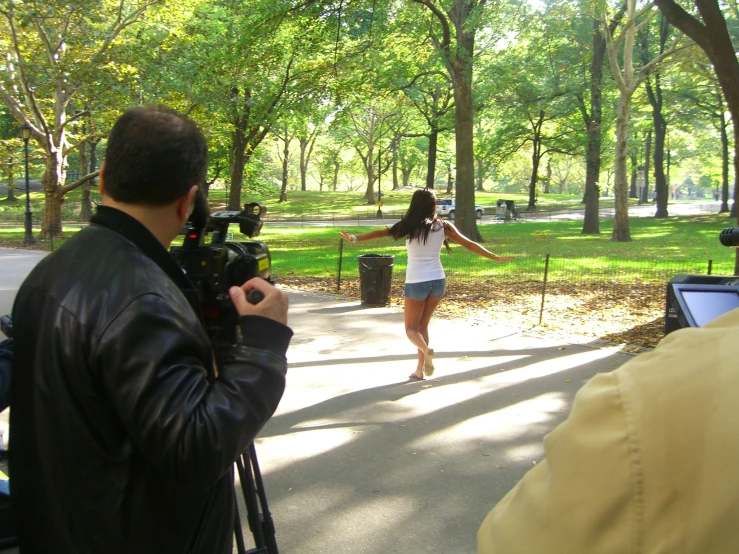 a woman that is standing up by some trees