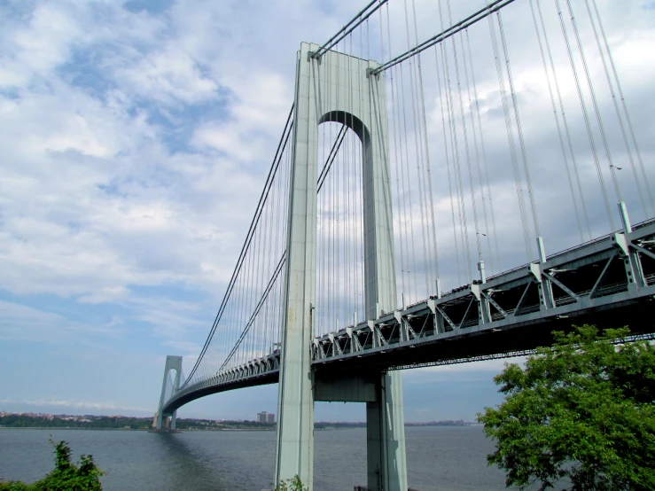 a bridge over water with trees and blue sky in the background