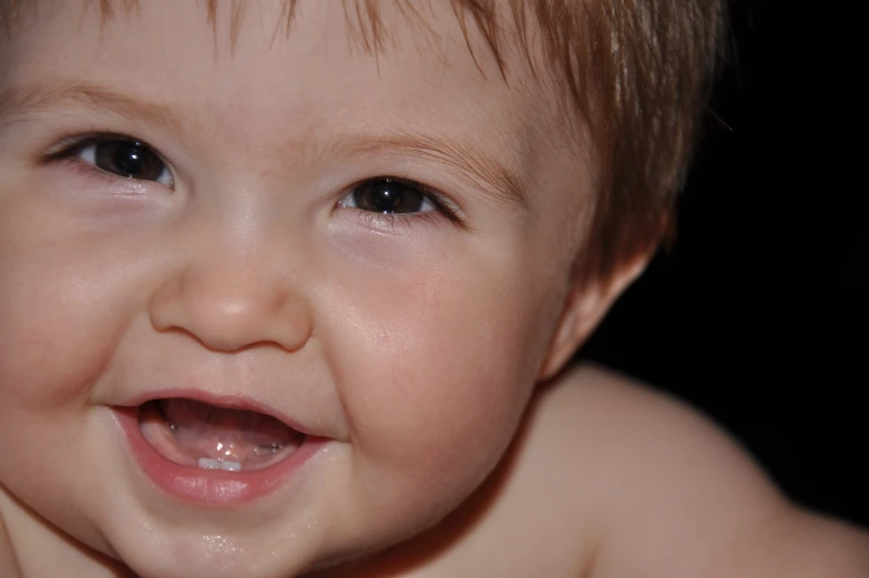 a close up of a baby with a big smile